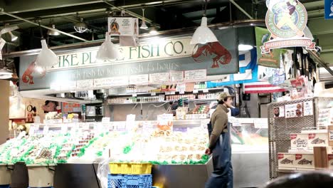 Pike-Place-Fish-Company-Im-öffentlichen-Marktzentrum-–-Fischhändler-Bedienen-Kunden-–-Bekannt-Dafür,-Dass-Sie-Ihren-Frisch-Gefangenen-Fisch-Den-Kunden-Zuwerfen