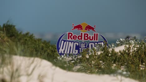 Red-Bull-King-of-the-Air-sign-amongst-dunes,-Bloubergstrand