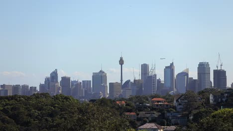 Ein-Flugzeug-Fliegt-Durch-Den-Klaren-Himmel-Der-Stadt-Sydney-Mit-Blick-Auf-Die-Hohen-Gebäude-Der-Stadtlandschaft