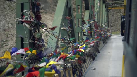 Tibetan-Flags-in-a-Bridge-over-a-Glacial-River---Mountain-Road-to-Indo-Tibetan-Border-in-The-Himalayas-North-India