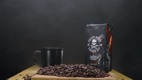 Foto-De-Producto-De-Estudio-Estático,-Paquete-De-Café-Con-Deseo-De-Muerte-Organizado-Con-Una-Taza-Humeante-Y-Frijoles-Oscuros-Y-Suaves