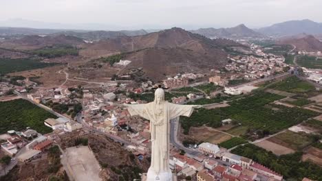 Gran-Estatua-De-Chirst-En-Monteagudo,-Cerca-De-La-Ciudad-De-Murcia,-Volando-Hacia-Atrás