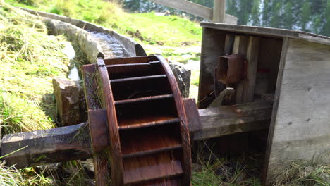 Hölzerner-Bewässerungskanal-Mit-Holzrad-Und-Glocke-Zur-Aktivitätskontrolle-Des-Fließenden-Wassers