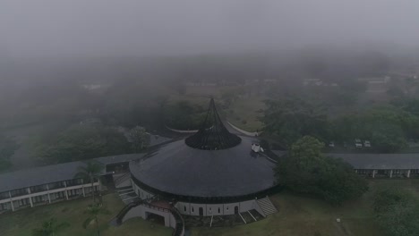 -Aerial-drone-shot-looking-down-on-the-Winkler-hotel-on-a-Misty-day-in-White-River,-the-hotel-embraces-a-traditional-African-theme-through-its-architecture-and-design,-Mpumalanga,-South-Africa