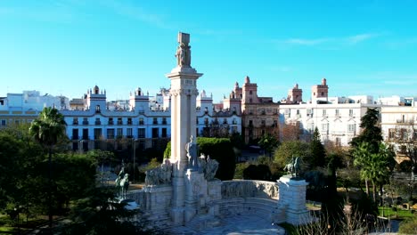 Aerial-view-of-statue-and-cityscape-of-Cadiz,-Spain-with-the-atlantic-ocean-in-the-background