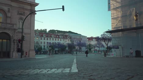 Empty-Lisbon-city-downtown,-ocasional-person-passing,-old-buildings-facade,-closed-stores,-during-covid-19-lock-down-4k