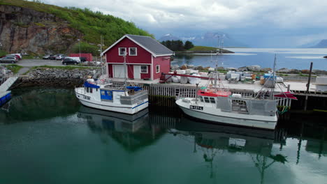 Aerial-Sliding-shot-of-Fishing-Vessels-at-Tonnes-Marina-in-Helgeland-on-a-calm-day-with-dramatic-sky