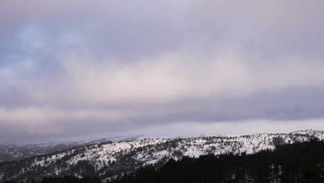 Espesas-Nubes-De-Tormenta-Invernal-Rodando-Sobre-Picos-Nevados,-Timelapse