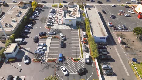 El-Lapso-De-Tiempo-De-Un-Dron-Captura-La-Fiebre-Del-Almuerzo-En-Un-Restaurante-De-Comida-Rápida-In-n-out-En-El-Soleado-Sur-De-California,-Los-Clientes-Esperan-En-Fila-Anhelando-Las-Icónicas-Hamburguesas-Y-Papas-Fritas,-Capturando-La-Verdadera-Esencia-De-La-Vida-Social.