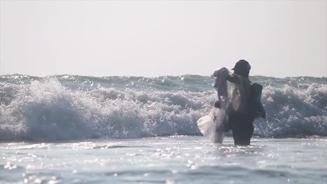 Standing-fisherman-prepares-set-net-amongst-breaking-waves---Cox's-Bazaar