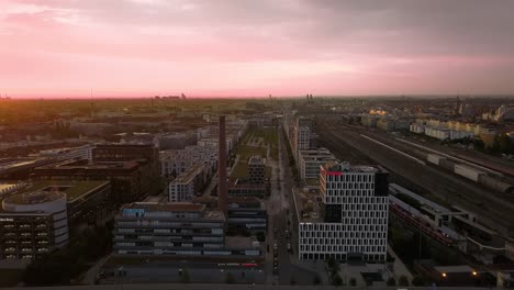 Munich-at-a-violet-sunrise---flight-over-business-buildings-and-driving-cars-in-the-early-morning-rush-hour-at-a-wide-view-over-the-bavarian-cityscape