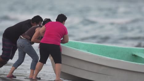 Fishermen-pushing-boat-out-to-sea