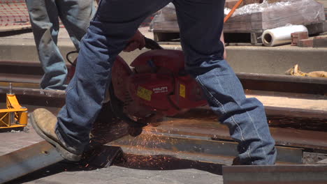 Closeup-video-of-construction-worker-cutting-steel-beams-for-railroad-tracks-in-slow-motion