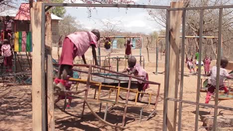 Niños-En-Kenia,-África,-Jugando-En-Un-Patio-De-Juegos-Escolar-En-Una-Zona-Semiárida