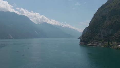 Panoramic-drone-view-of-the-lake-garda-in-Riva-Del-Garda,-a-small-city-in-the-region-of-Trentino-North-Italy,-Gardalake-with-italian-alps-in-the-background