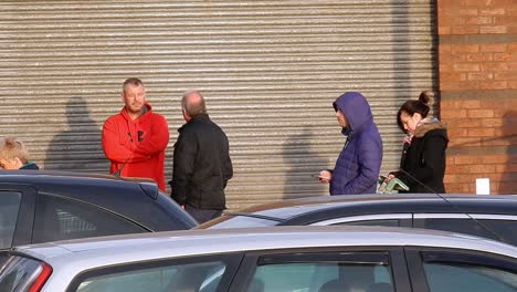 Cornona-Covid-virus-shoppers-panic-buying-waiting-at-corrugated-store-doors-UK-retail