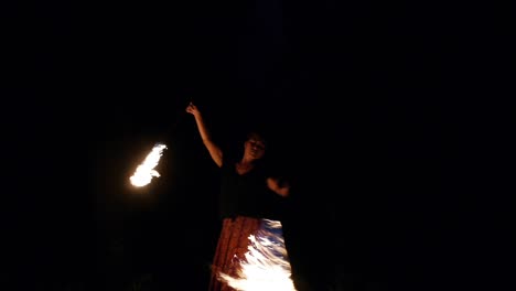 Asian-woman-using-fire-ropes-to-spin-figure-of-8-in-dark