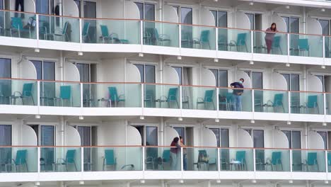 Passengers-under-quarantine-stand-on-balconies-aboard-the-Dream-World-cruiser-which-docks-at-Kai-Tak-Cruise-Terminal-in-Kowloon-Bay,-Hong-Kong