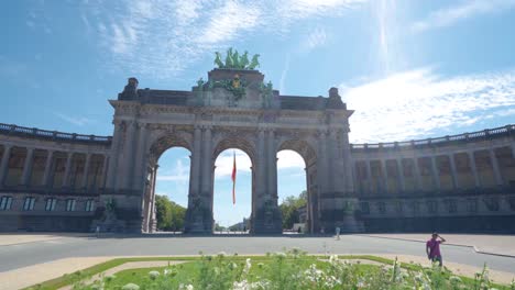 Upwards-shot-from-flowerbed-to-the-triumph-arc,-arc-de-triomphe,-at-the-cinquantennaire-urban-park-in-Brussels,-Belgium,-on-a-warm-sunny-summer-day