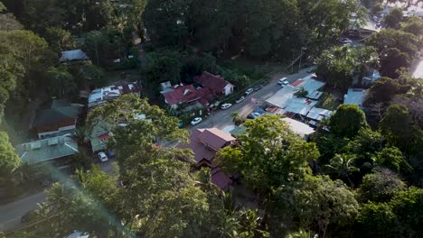 Flying-over-trees-and-over-a-small-road-of-Puerto-Viejo-de-Talamanca-in-Costa-Rica