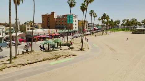 Establishing-drone-shot-Venice-Beach-seafront-city-with-tourists