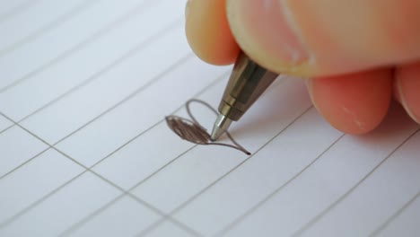 Black-Pen-Drawing-Love-Heart-on-Lined-Paper,-Extreme-Close-Up