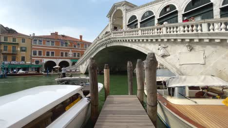 Turistas-Montando-Góndola-Bajo-El-Famoso-Puente-De-Rialto-En-Venecia,-Italia