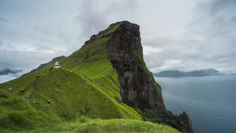 Lighthouse-on-green-mountain-with-sunset-moving-clouds-time-lapse-slider