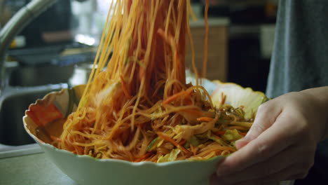 Mixing-in-Korean-chili-paste-in-with-jjolmyeon-noodles-to-create-Korean-Spicy-Chewy-Noodles-in-a-large-bowl