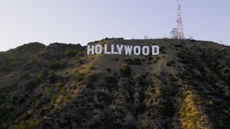 Aerial-view-around-the-Hollywood-sign,-in-Griffith-park,-golden-hour-in-Los-Angeles,-USA---circling,-drone-shot