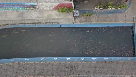 Aerial-view,-slum-river-flow-becomes-clean-and-there-are-fish-in-Lepen-Dam