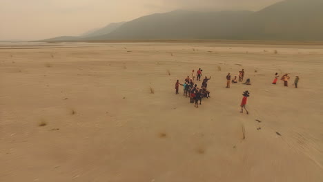 drone-aerial-of-desert-lahar-old-lava-from-pinatubo-with-volcano-as-background-with-camera-crew-production-unit-carrying-Arri-Alexa