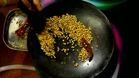 top-down-view-of-dry-roasting-spices-by-indian-local-woman-at-home