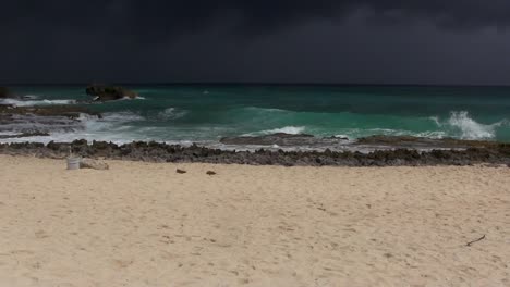 View-from-a-sandy-beach-as-an-ominous-storm-approaches,-with-rain-visible-in-the-distance