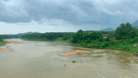 Eine-Wunderschöne-Landschaft-Mit-Einem-See,-Der-Nach-Einem-Regen-In-Kerala-Fließt,-Mit-Bergen-Und-Grünflächen-Im-Hintergrund