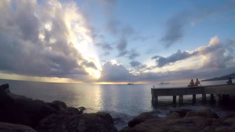 Zeitraffer-Von-Menschen,-Die-Auf-Einem-Gerüst-Sitzen,-Mit-Dem-Sonnenuntergang-Am-Horizont-An-Einem-Teilweise-Bewölkten-Sommertag-In-Martinique