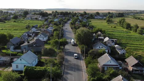 Aerial-View-of-Semi-Truck-and-Van-Driving-Through-Countryside-Neighborhood-in-Ukraine