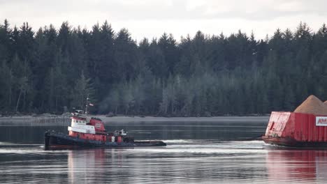 A-tugboat-pulling-a-large-barge-of-wood-chips-for-the-timber-industry