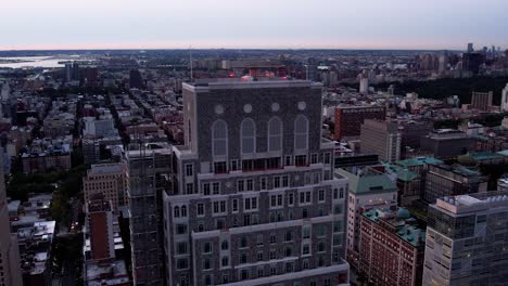 Aerial-view-around-the-top-of-the-Claremont-hall,-dusk-in-Morningside-Heights,-NYC---orbit,-drone-shot