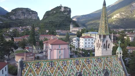 Langsam-Bewegte-Drohne-Schoss-über-Eine-Alte-Bunte-Kirche-In-Einem-Alten-Italienischen-Dorf,-Arco-In-Der-Nähe-Von-Riva-Del-Garda,-Trentino