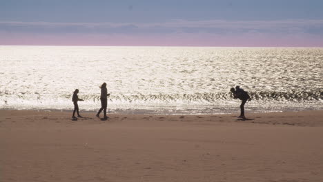 Family-hanging-out-on-the-beach-at-sunset