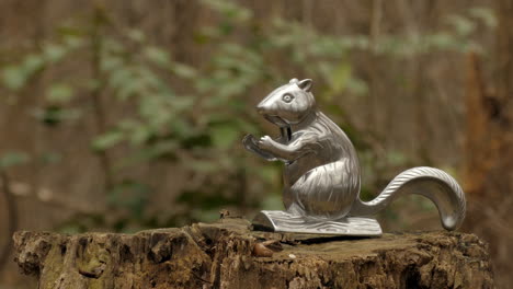 Metal-Squirrel-Nutcracker-on-Stump-in-Forest---Closeup