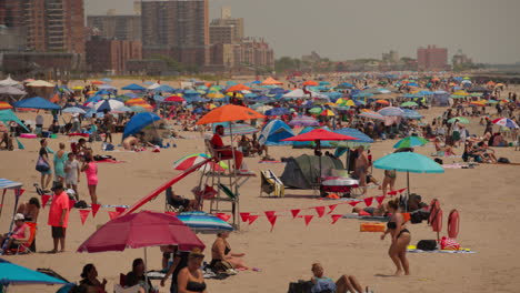 Crowd-of-people-at-beach,-Coney-Island-holiday-resort-in-summer,-New-York,-US