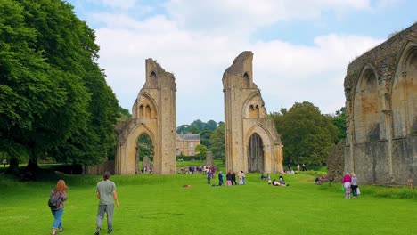 People-visiting-historical-Glastonbury-Abbey-grounds-and-building-ruins-in-Isle-of-Avalon,-Somerset,-England-UK