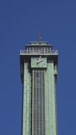 Clock-lookout-tower-of-Nova-Radnice-town-hall-in-Ostrava,-several-tourists-looking-down,-vertical-video