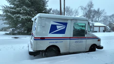 Aerial-close-up-shot-of-american-usps-united-states-postal-service-on-snowy-street-in-winter