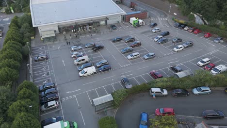 Aerial-orbital-view-of-Waitrose-supermarket-and-its-spacious-carpark,-located-in-the-heart-of-Holsworthy,-Devon,-United-Kingdom,-June-2024