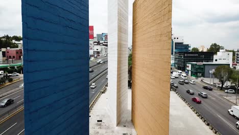 Drone-flight-shot-flying-between-the-blue-tower-and-the-white-tower-in-Ciudad-Satelite,-a-housing-suburb-of-Mexico-City