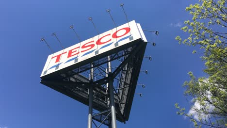 Large-triangular-advertisment-banner-tower-of-Tesco-department-store,-static-shot