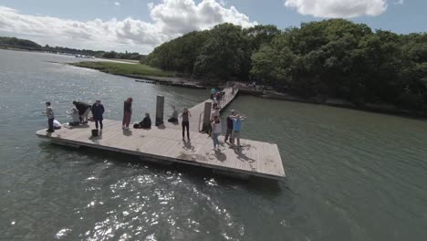 Filmisches-Nahaufnahmevideo-Eines-Jungen-Und-Fitten-Mannes,-Der-An-Einem-Heißen-Und-Sonnigen-Tag-An-Der-Südküste-Englands-Ins-Wasser-Rennt-Und-Springt